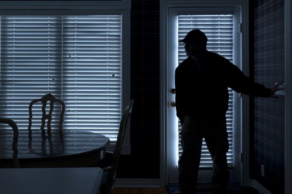 man enters room dark home security monitoring